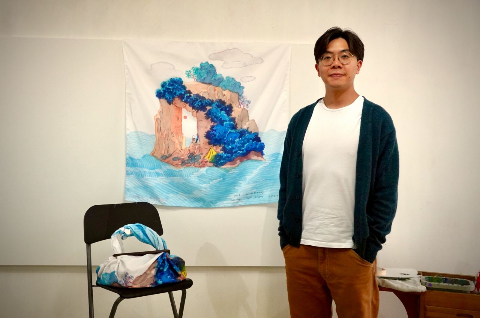 Artist Stephen Wong with the artwork for A Hundred Islands